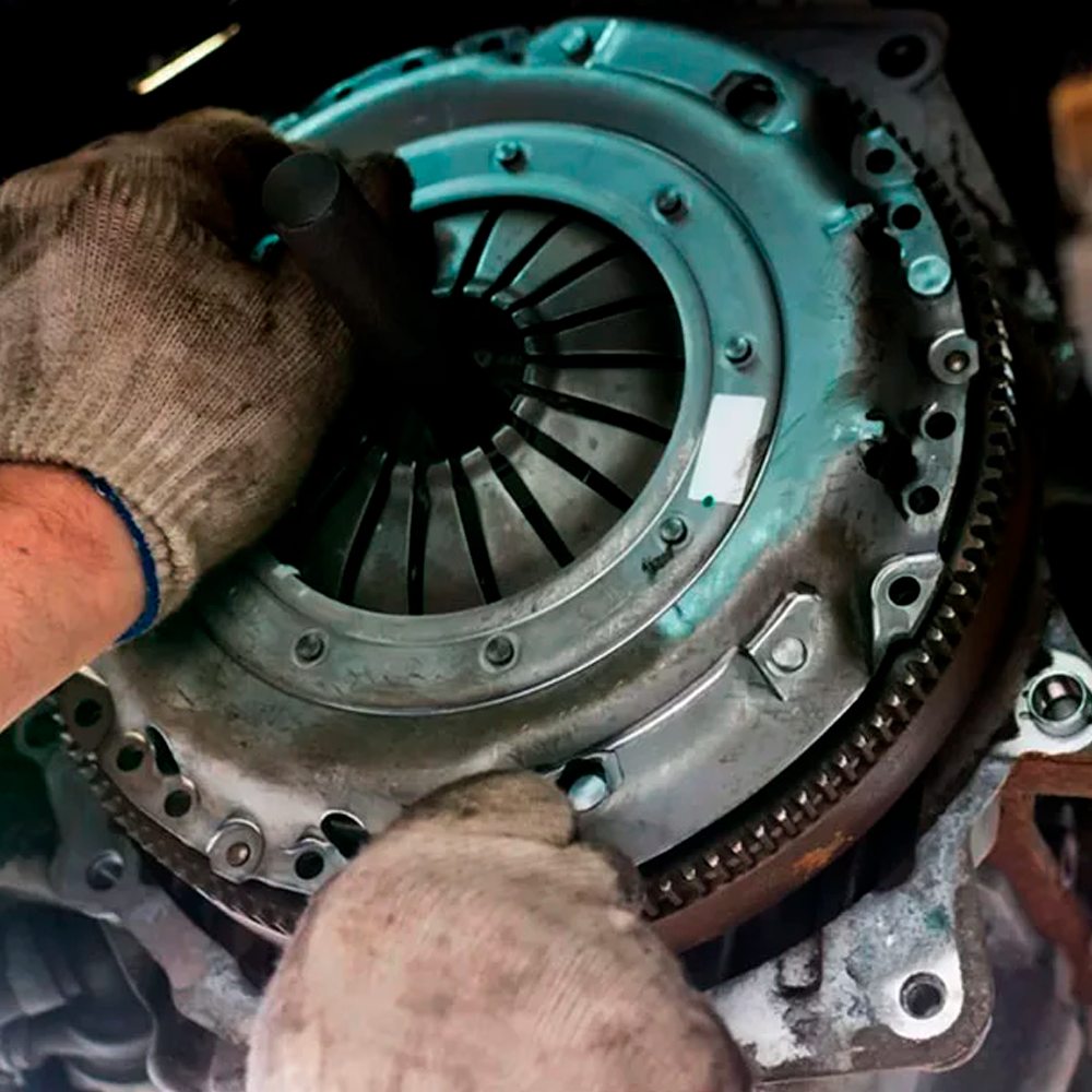 Mecânico instalando platô de embreagem no volante do motor